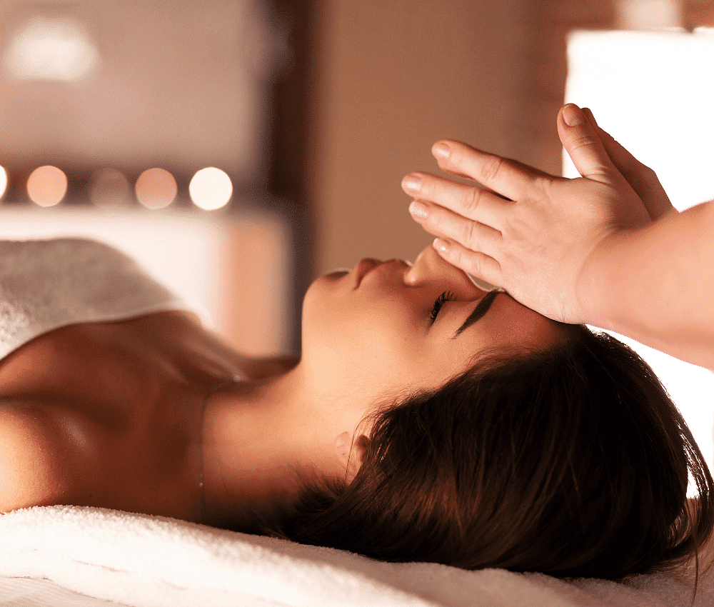 Woman receiving a forehead massage in a serene spa setting.