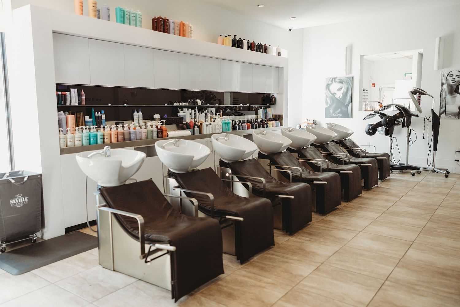 Interior of a hair salon with washing stations and product shelves.