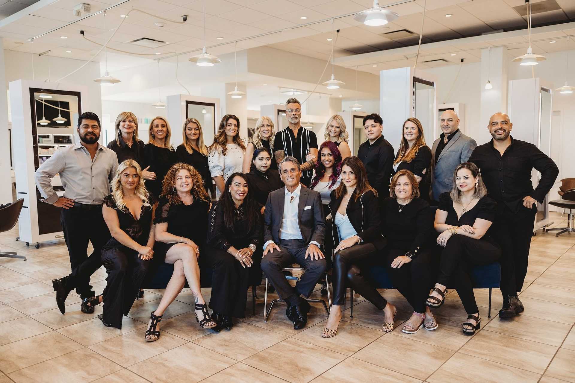 Group of hairstylists posing together in a salon interior.